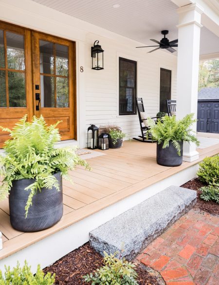 gorgeous front porch home design filled with concrete planters with lush, green plants