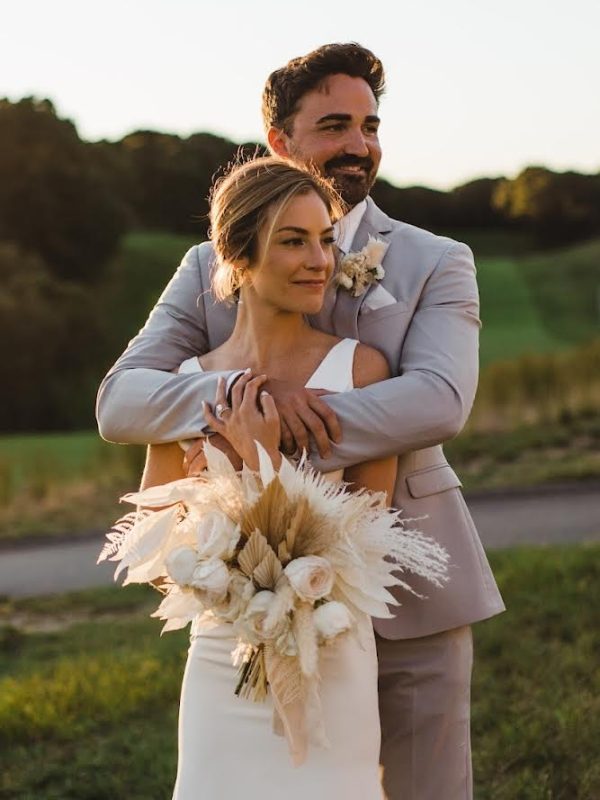 bride and groom at outdoor wedding venue with gorgeous wedding bridal bouquet