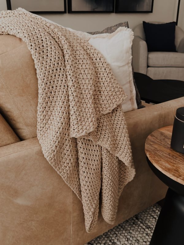 gorgeous living room with a blanket placed over the couch